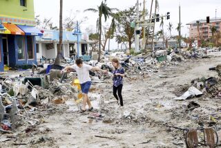 Jake Moses, de 19 años, a la izquierda, y Heather Jones, de 18, exploran una sección de negocios destruidos, el jueves 29 de septiembre de 2022, en Fort Myers Beach, Florida. (Douglas R. Clifford/Tampa Bay Times via AP)
