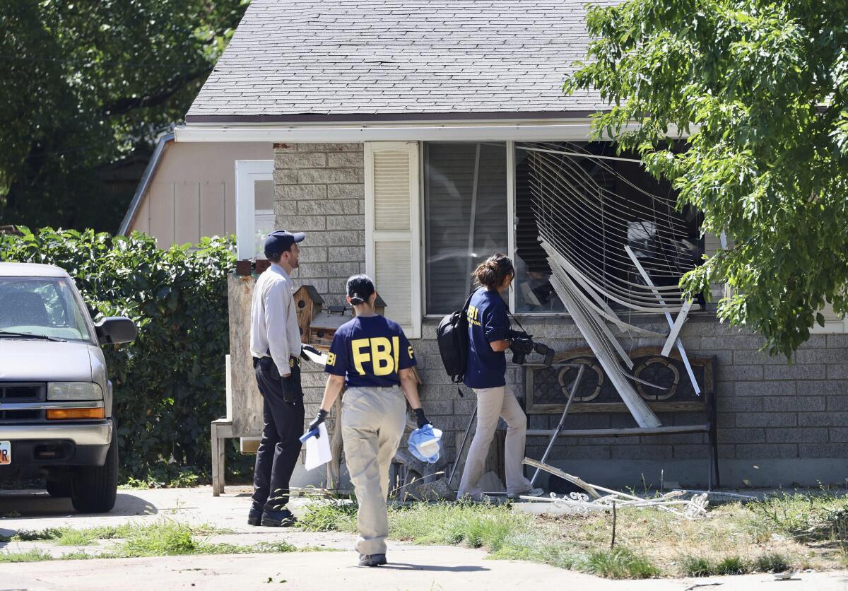 Law enforcement agents investigate the scene of a shooting involving the FBI in Provo, Utah. 