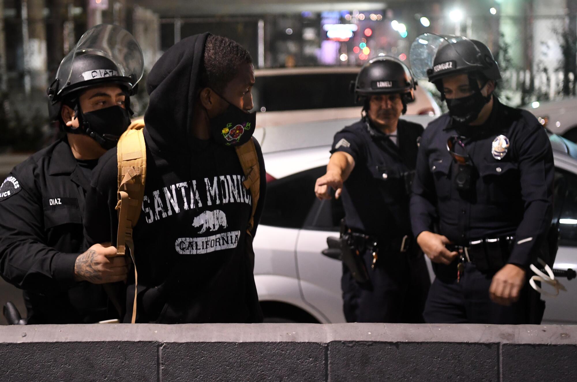 Police detain protesters near 18th and Figueroa streets in downtown Los Angeles on Tuesday night.