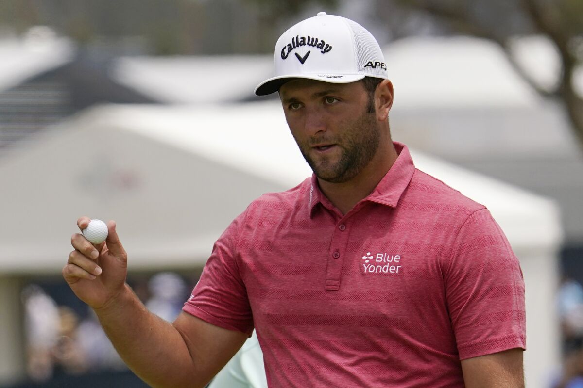 FILE - In this June 20, 2021, file photo, Jon Rahm, of Spain, waves after his putt on the first green during the final round of the U.S. Open Golf Championship at Torrey Pines Golf Course in San Diego. Rahm has tested positive for COVID-19 for the second time in two months and the Spaniard has been knocked out of the Olympics only a few hours after American golfer Bryson DeChambeau met the same fate. (AP Photo/Gregory Bull, File)