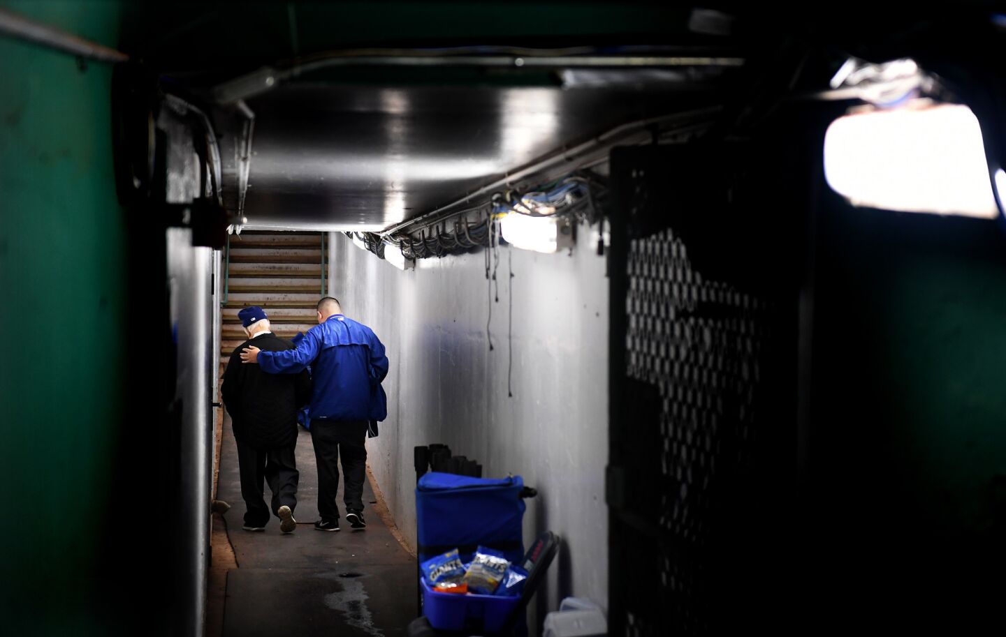 Dodgers Tommy Lasorda walks through a tunnel with caretaker Felipe Ruiz during a Dodger work out at Fenway Park in Boston.