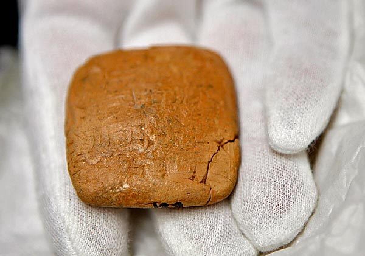 Marilyn Lundberg, an associate with the West Semitic Research Project, holds a 4,000-year-old tablet deciphered by a process called reflectance transformation imagery at USC's Ahmanson Center. Through the imagery process Lundberg is able to see that the tablet is written in a Sumerian language and lists laborers.