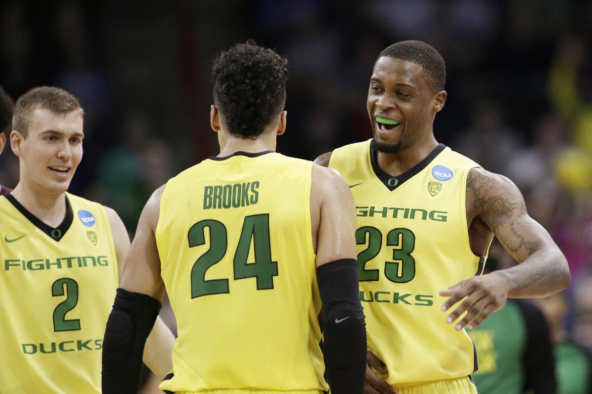 Oregon guard Casey Benson (2) and forwards Dillon Brooks (24) and Elgin Cook (23) celebrate during the second half of their victory over Saint Joseph's.