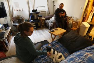 Mar Vista, Los Angeles, California-Nov. 30, 2021-Newlyweds Cara Ferraro, left, and Jack Shain, right, share a one-bedroom apartment in Mar Vista with their two cats, Zelda and Bucky, on the couch. Cara works from home in media production, while Jack Shain works with patients at a drug and alcohol center he opened last year with a partner during the pandemic. They have been through ups and downs in their first year of marriage due to the stresses of working at home and dealing with COVID scares, but things seem to have stabilized now. (Carolyn Cole / Los Angeles Times)