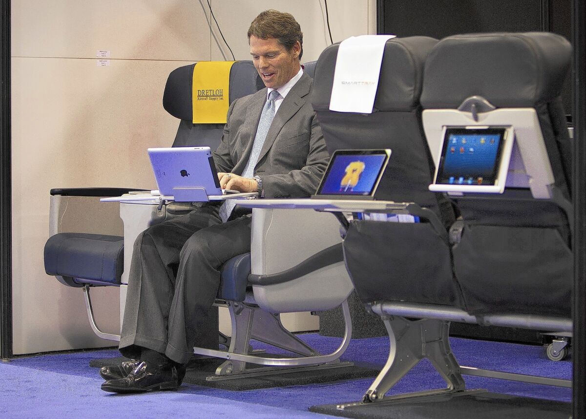 David Coppock demonstrates the SmartTray, an airline tray table designed to hold tablet computers and smartphones, at the Apex Expo in Anaheim in September.