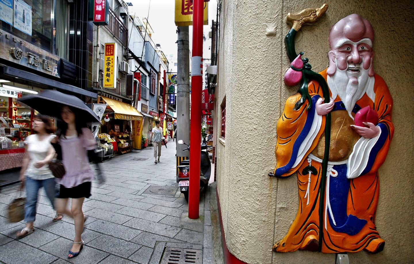 People walk through an alley in Nagasaki's Chinatown, one of the largest Chinatowns in Japan.