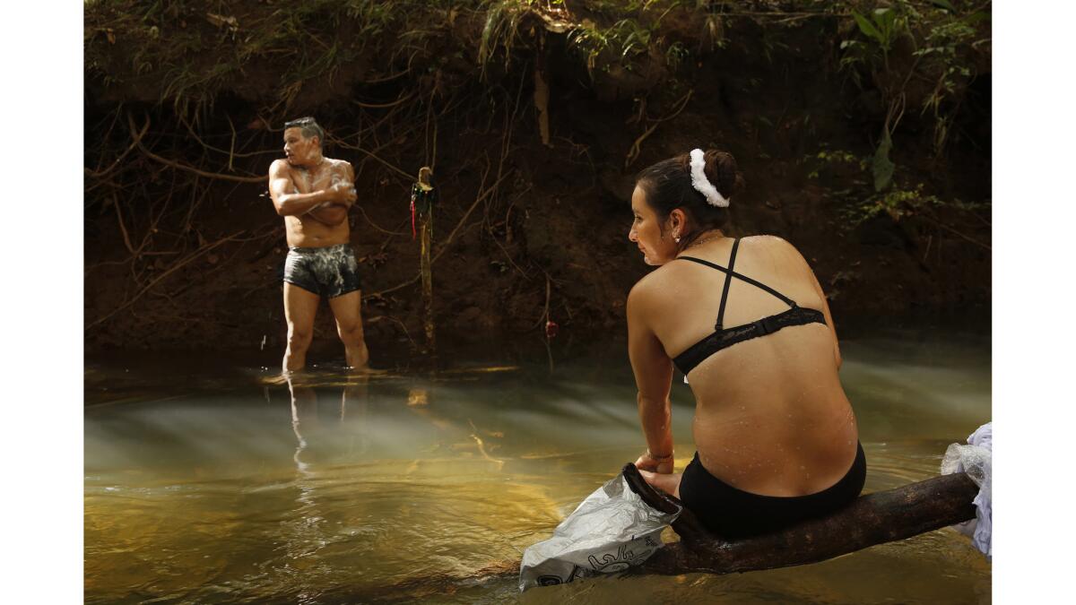 FARC member Viviana, age 28, right, and her comrade Jon, 34, bathe in the spring waters next to their camp.