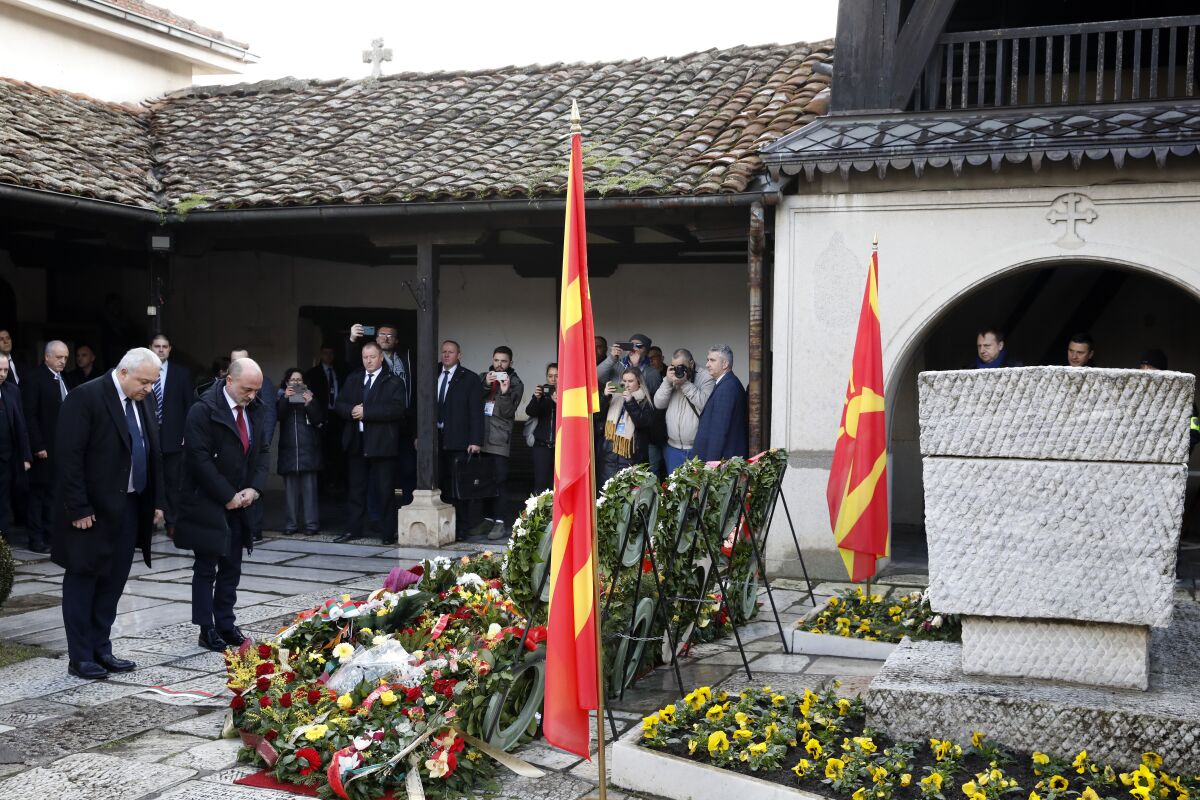 Bulgaria's Interior Minister Ivan Demerdzhiev, left and the health minister Assen Medjidiev, second from left pay bow at the grave of Goce Delcev, a revolutionary who opposed Ottoman rule in the Balkans that ended after hundreds of years in the early 20th century, at the church of the Ascension of Jesus, in Skopje, North Macedonia, Saturday, Feb. 4, 2023. North Macedonia on Saturday honoured the birth of 19th century revolutionary hero Goce Delcev with tight security amid fears of potential clashes between opposing nationalist groups from North Macedonia and Bulgaria, as both countries have claims of the historic figure. (AP Photo/Boris Grdanoski)