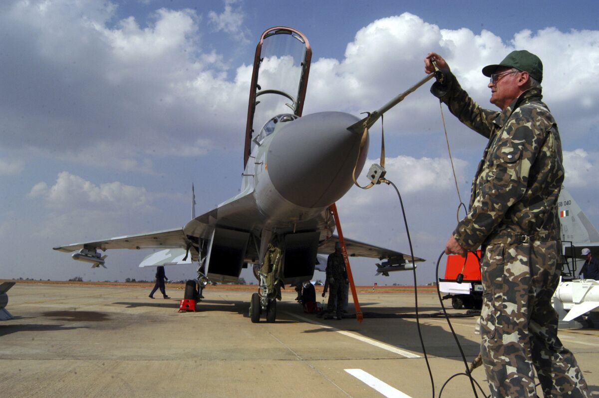 FILE- A Russian technician prepares for the take-off of the MIG 29 M2 ahead of the 5th edition of the Aero India show at the Yelahanka Air Force Station in Bangalore, India, Feb. 6, 2005. India on Thursday said it would ramp up its production of military equipment, including helicopters, tank engines, missiles and airborne early warning systems, to offset any potential shortfall from its main supplier Russia. India depends on Russia for nearly 60% of its defense equipment, and the war in Ukraine has added to doubts about future supplies.(AP Photo/Gautam Singh, File)