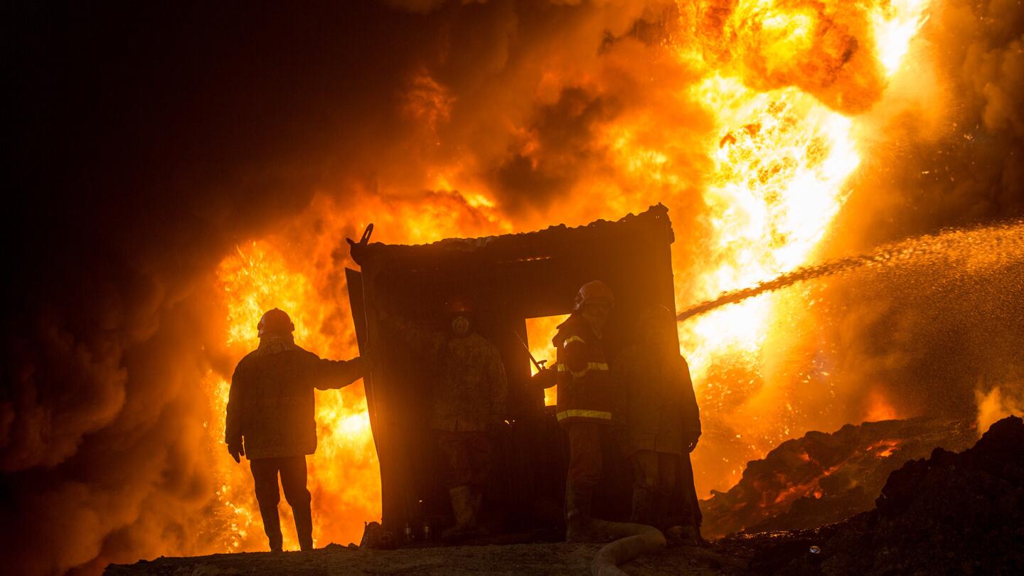 A firefighter works to extinguish an oil well set ablaze by fleeing Islamic State fighters in Qayyarah, Iraq, on Nov. 9.