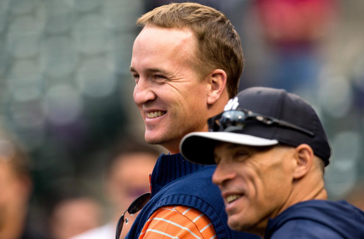 Peyton Manning shares a laugh with Yankees Manager Joe Girardi during batting practice before a game against the Colorado Rockies at Coors Field earlier this month.