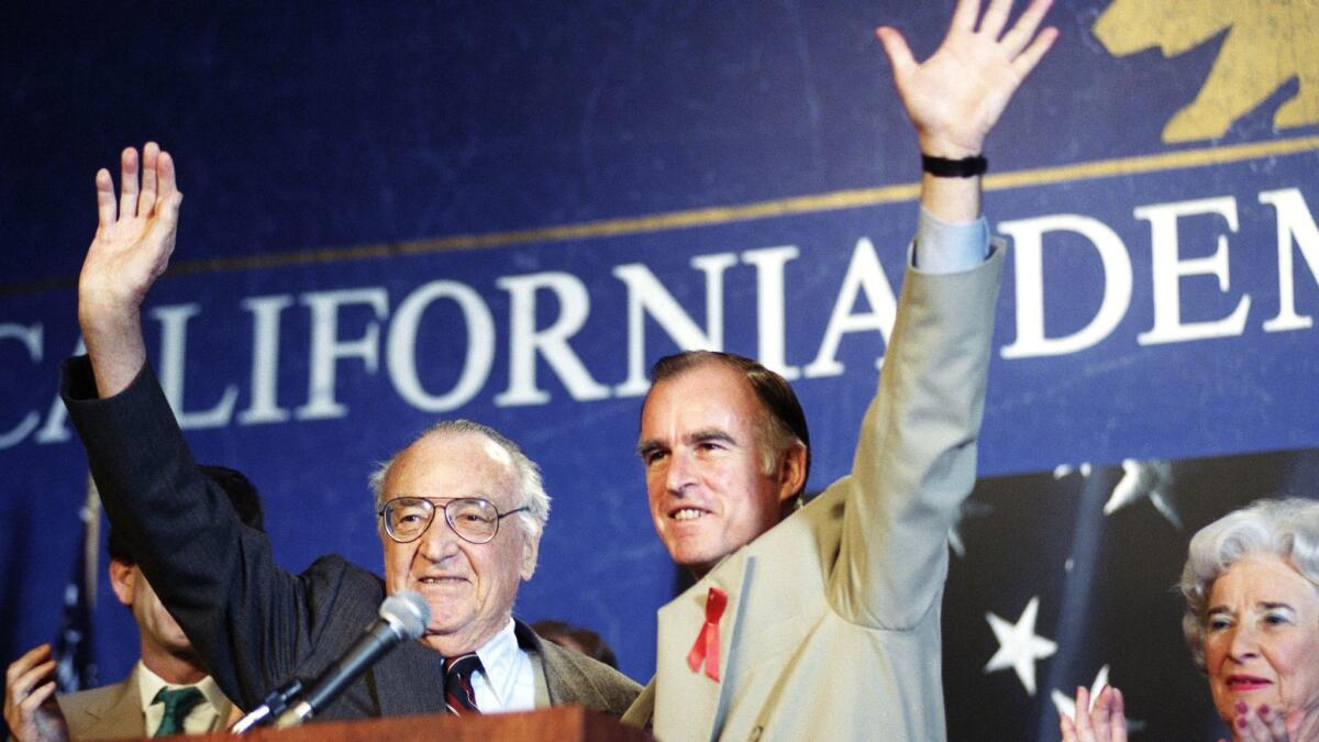 Former Govs. Jerry Brown, right, and his father, Edmund G. Pat Brown, acknowledge the crowd at the California Democratic Party's convention in Los Angeles on April 11, 1992. Pat Brown was governor from 1959 to 1967. Jerry Brown served his first stint from 1975 to 1983.