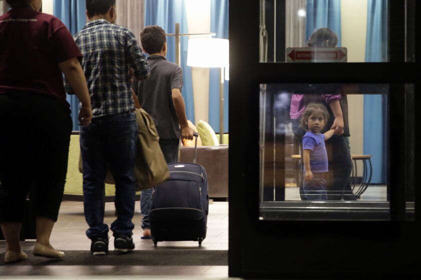 FILE - Immigrants seeking asylum who were recently reunited arrive at a hotel in San Antonio, July 23, 2018. The Biden administration is asking that parents of children separated at the U.S.-Mexico border undergo another round of psychological evaluations in an effort to measure how just traumatized they were by the Trump-era policy, court documents show. (AP Photo/Eric Gay, File)