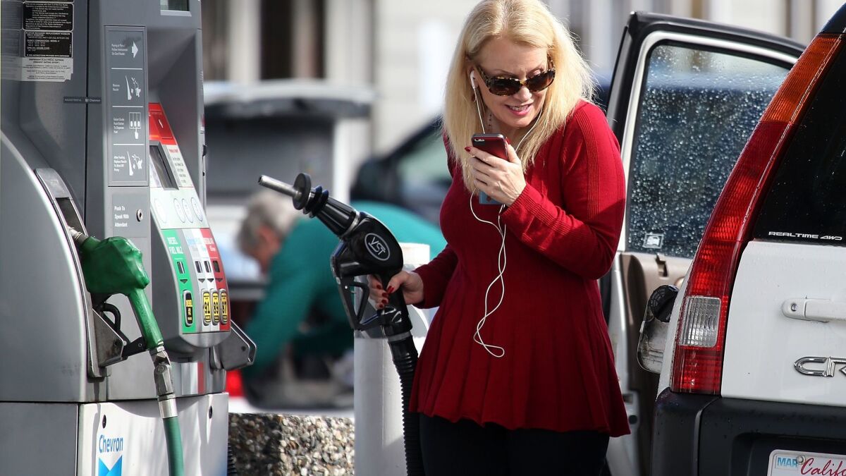 A motorist prepares to gas up her vehicle in San Rafael, Calif., in 2015. The state's gas tax increases are expected to remain controversial throughout 2018.