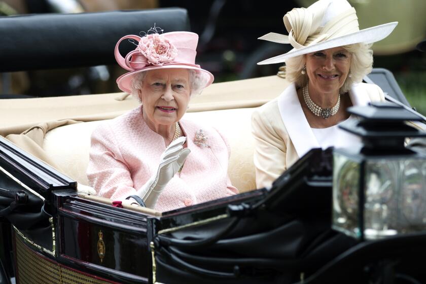 FILE - Britain's Queen Elizabeth II waves to the crowds with Camilla, Duchess of Cornwall at right, as they arrive by carriage on the first day of the Royal Ascot horse race meeting in Ascot, England, Tuesday, June 18, 2013. Queen Elizabeth II has offered her support to have the Duchess of Cornwall become Queen Camilla — using a special Platinum Jubilee message to make a significant decision in shaping the future of the monarchy. (AP Photo/Alastair Grant, File)