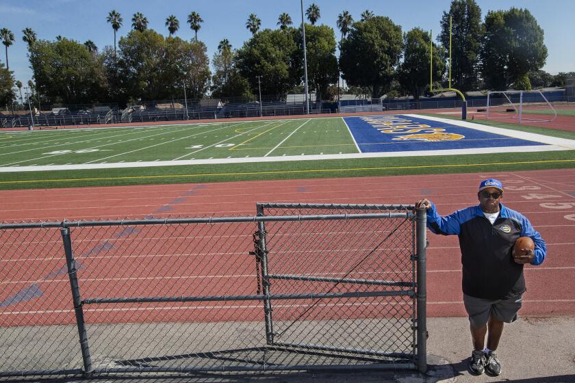 LOS ANGELES, CA - OCTOBER 20, 2021: Robert Garrett, head coach of the Crenshaw High School varsity football team, is photographed near the football field at the school. Crenshaw football team members have spent the week in quarantine, unable to practice, with this Friday's game against Locke High School looking unlikely. Last Friday, Crenshaw High School played a game against View Park Preparatory High School, a charter school authorized by L.A. Unified, that switched to remote learning for this week after enough students tested positive for the coronavirus to raise concerns. (Mel Melcon / Los Angeles Times)