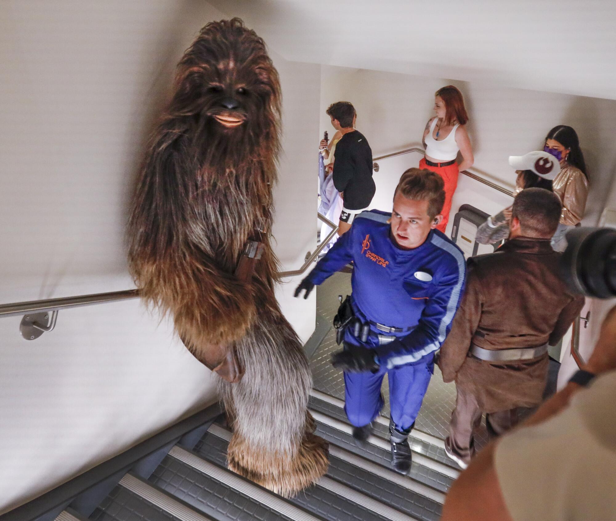 Sammie, the ship's mechanic, center, leads Chewbacca, a legendary Wookiee warrior.
