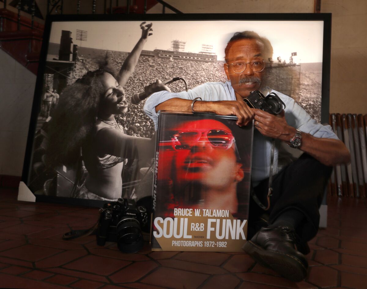 hotographer Bruce Talamon sits next to a photograph of singer Chaka Khan, background, that he made back in 1977 at the Los Angeles Coliseum, during the P-Funk Earth Tour.