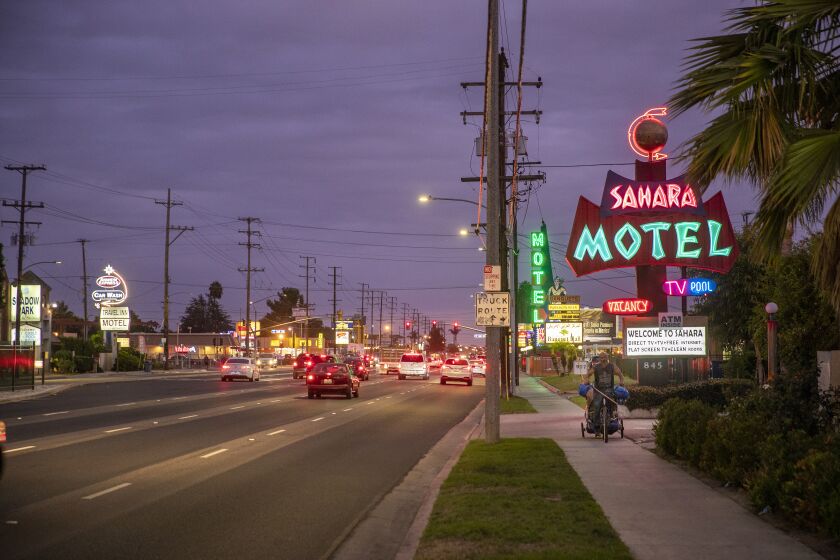 Anaheim, CA - March 27: A person rides along Beach Boulevard, past motels and hotels in Anaheim in 2019. Beach Boulevard is an iconic 21-mile highway in Orange County that leads to the beach. But for decades, inland cities have been saddled with out of date, rundown motels that serve more as magnets for crime than tourism around Knott's Berry Farm. Anaheim, Buena Park and Stanton have all charted their own paths on how to deal with the motels in the way of redeveloping Beach Boulevard into a destination again. (Allen J. Schaben / Los Angeles Times)