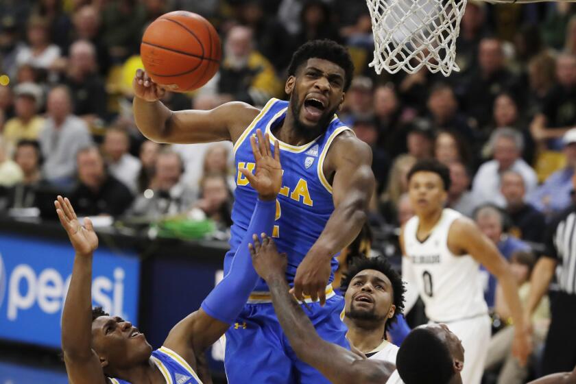 UCLA forward Cody Riley, center, blocks a shot by Colorado guard McKinley Wright IV, right, as UCLA guard David Singleton pulls in the loose ball in the second half of an NCAA college basketball game Saturday, Feb. 22, 2020, in Boulder, Colo. (AP Photo/David Zalubowski)sc