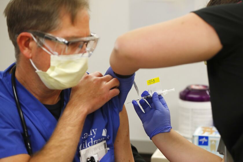 SAN DIEGO, CA - DECEMBER 15: Nurse Practitioner Dan Jacobson gets a Pfizer-BioNTech COVID-19 Vaccine shot from RN Rachel Marrs at Rady ChildrenOs Hospital on Tuesday, Dec. 15, 2020 in San Diego, CA.(K.C. Alfred / The San Diego Union-Tribune)