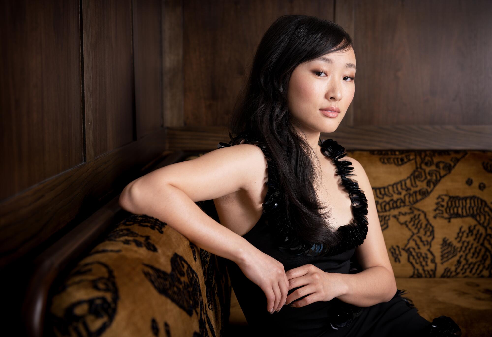  Ji-young Yoo rests an arm on the back of a couch for a portrait.