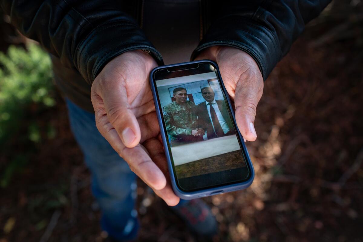 Emal Salarzai holds a photo of his father shaking the hand of retired U.S. Army Gen. David H. Petraeus.