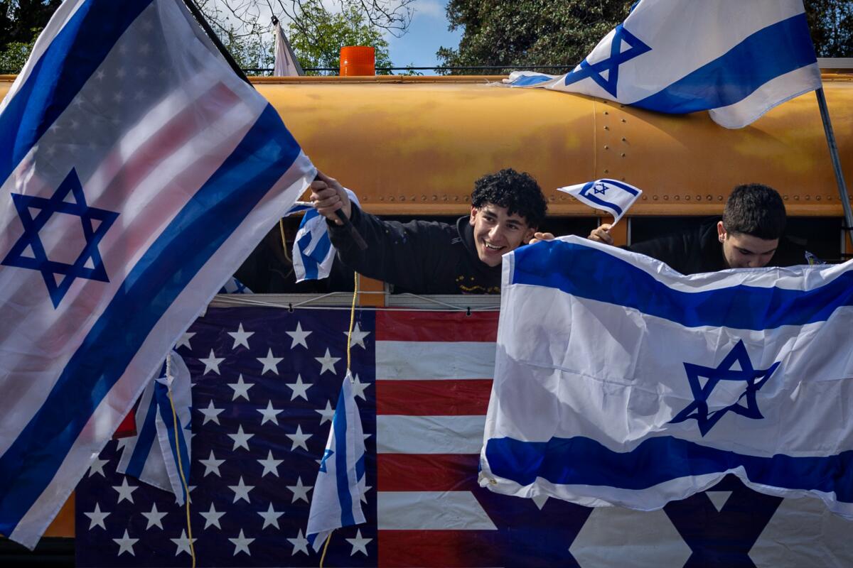 Students at El Camino Real Charter High School hold Israeli flags during a walkout.