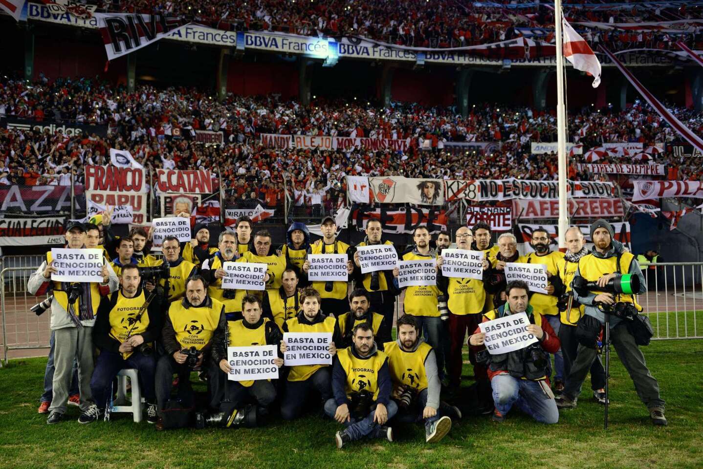 Argentine photographers pose with signs reading "Enough of genocide in Mexico" before the Libertadores Cup second leg final match between Argentinian River Plate and Mexican Tigres at Americo Vespucio stadium, in Buenos Aires, on August 5, 2015. The death of Mexican news photographer Ruben Espinosa in a gory five-victim homicide has unleashed new fears for other journalists in the country. AFP PHOTO/CHARLY DIAZ AZCUECharly Diaz Azcue/AFP/Getty Images ** OUTS - ELSENT, FPG - OUTS * NM, PH, VA if sourced by CT, LA or MoD **