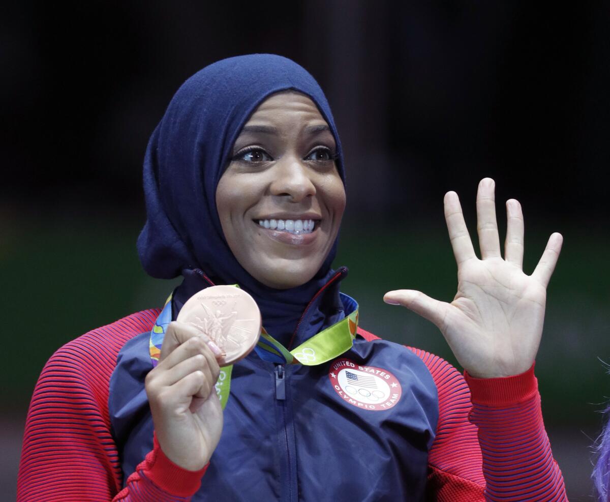 American athlete Ibtihaj Muhammad poses with her bronze medal after the women's team sabre fencing competition at the 2016 Summer Olympics in Rio de Janeiro.