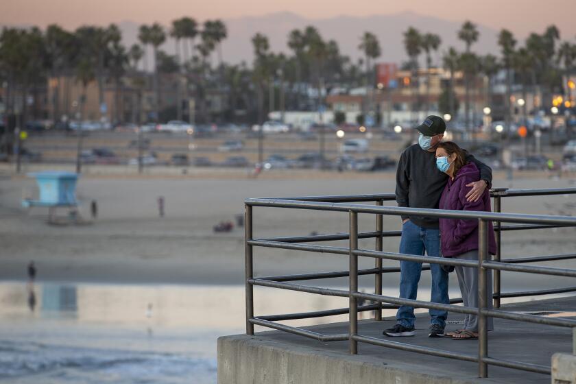 Randall and Jennifer Harris, watch the sunset at Huntington Beach Pier on Monday, November 30.