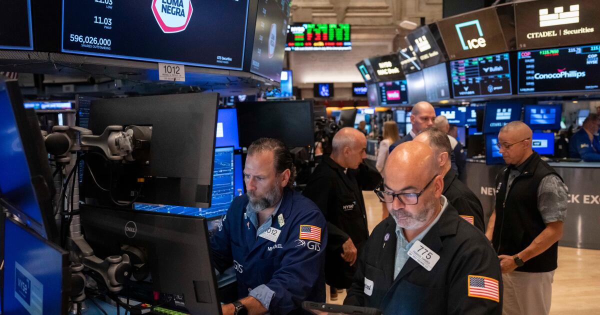 Photo: latimes.com Trader Fred Demarco, right, and Specialist Michael Pistillo, left, work on the floor of the New York Stock Exchange, Friday
