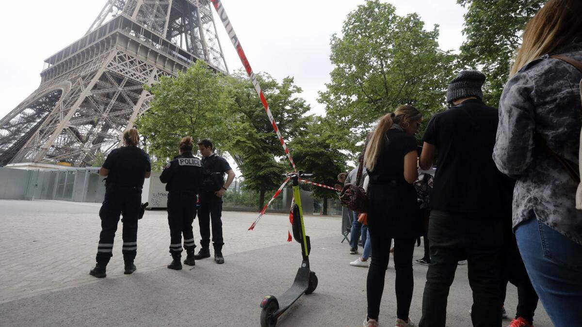 French police prevent tourists from nearing the Eiffel Tower after a man began climbing the Paris monument on May 20, 2019.