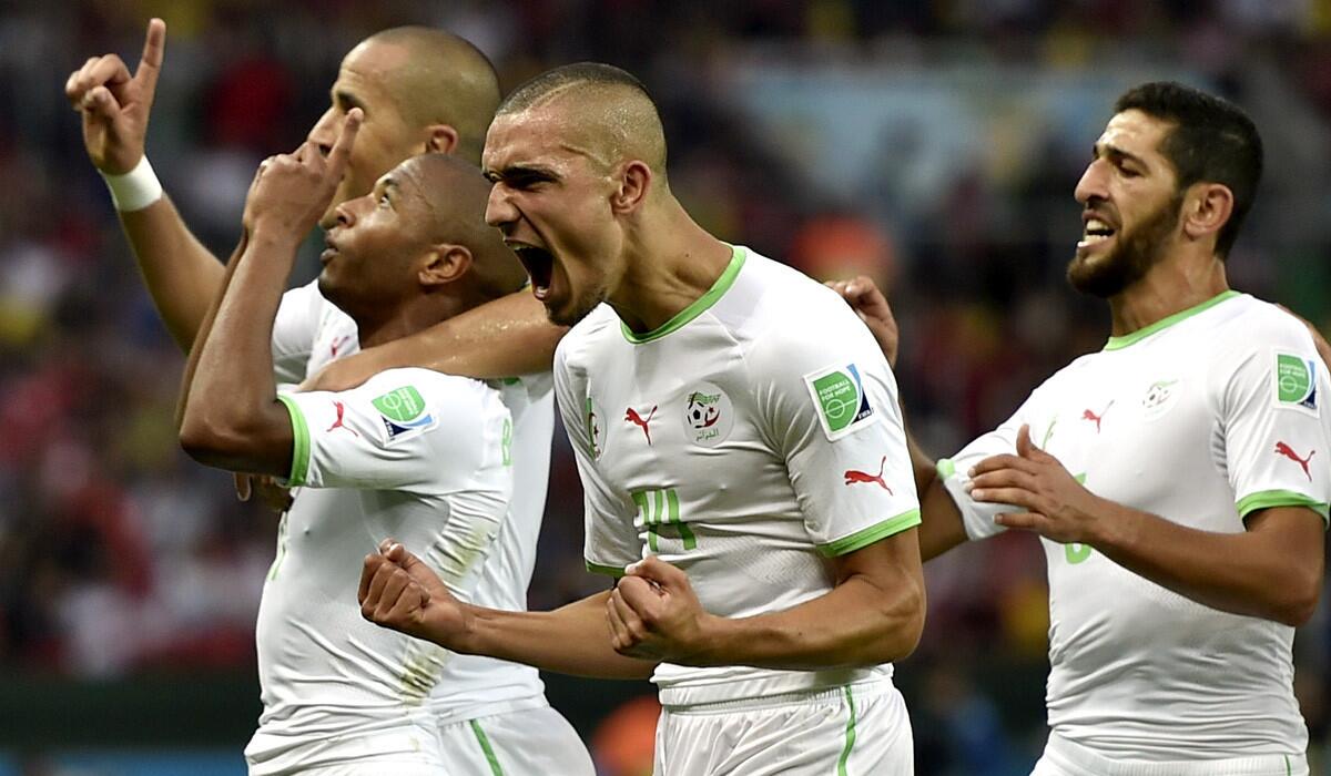 Algerian teammates celebrate after Yacine Brahimi, front left, scored their final goal in a 4-2 victory over South Korea at the Estadio Beira-Rio in Porto Alegre, Brazil.