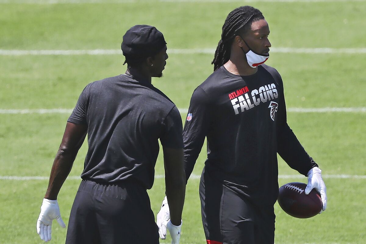 FILE - In this Aug. 4, 2020, file photo, Atlanta Falcons running back Todd Gurley, right, gets five from wide receiver Calvin Ridley after making a reception during NFL football practice in Flowery Branch, Ga. Gurley believes he and his new team are a perfect match as he seeks to rejuvenate a career affected by knee injuries. (Curtis Compton/Atlanta Journal-Constitution via AP)