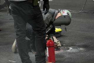 A worker repairs a hole on the Formula One track in Las Vegas that was damaged during practice Thursday