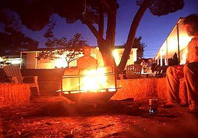 With nearly 2,200 northbound miles yet to go, a pair of PCT hiker savor the campfire in the backyard of a home along the trail in Agua Dulce.