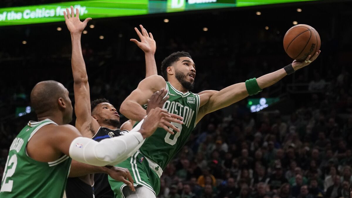 Celtics forward Jayson Tatum reaches out his left arm for a layup.