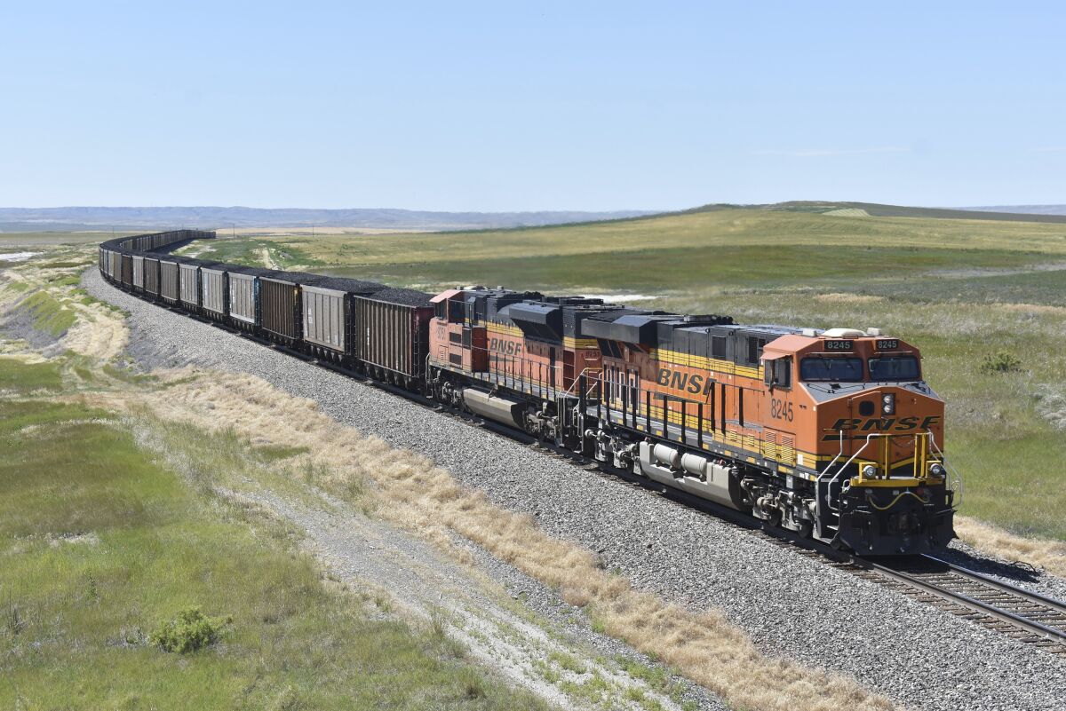 FILE - A BNSF railroad train hauling carloads of coal from the Powder River Basin of Montana and Wyoming is seen east of Hardin, Mont., on July 15, 2020. BNSF railroad wants a federal judge to prevent two of its unions from going on strike next month over a new attendance policy that would penalize employees for missing work. The Fort Worth, Texas-based railroad went to court after the unions that represent nearly half of BNSF's 35,000 workers threatened to strike over the new policy that is set to go into effect on Feb. 1, 2022. (AP Photo/Matthew Brown File)