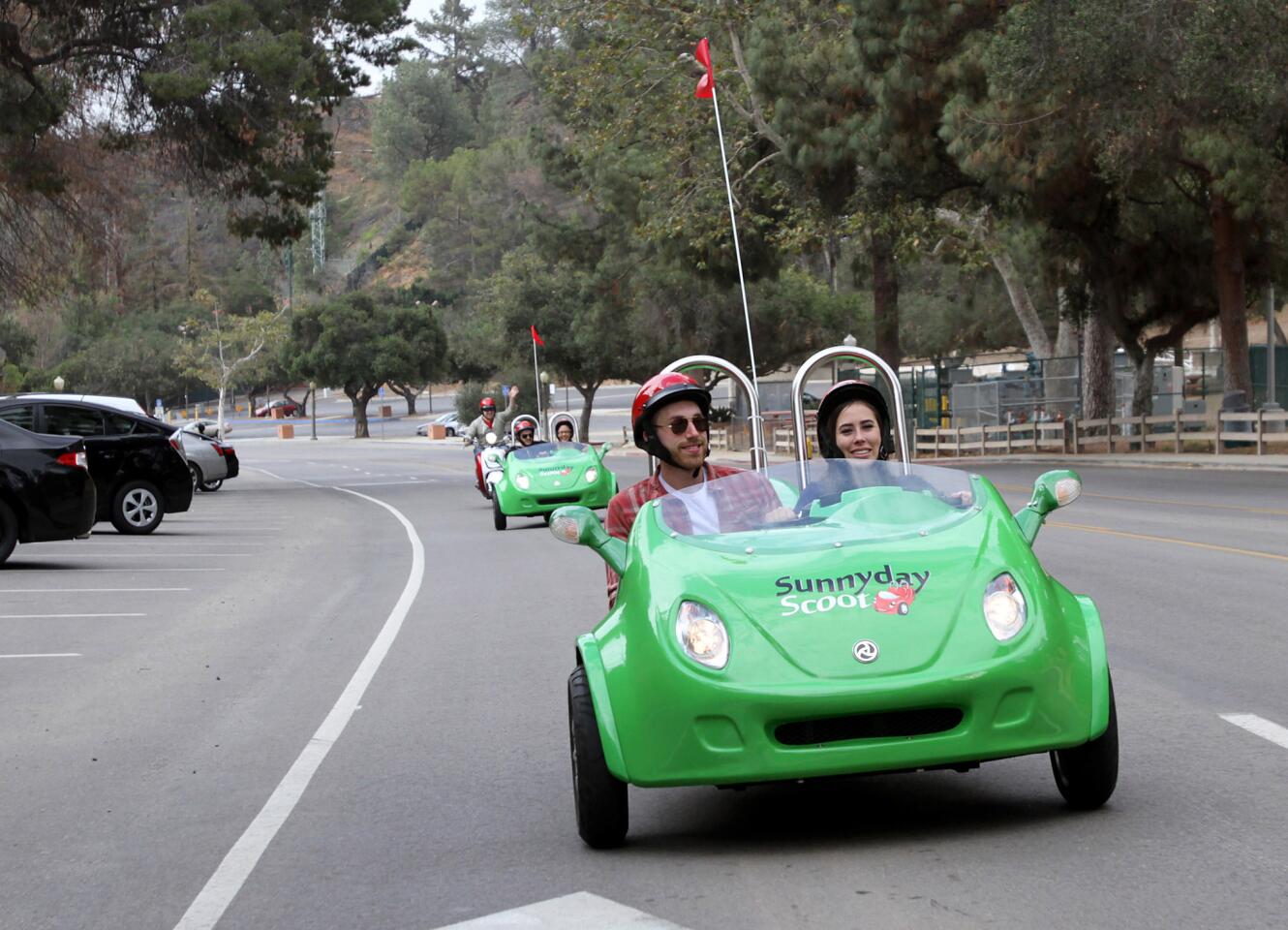 Taylor Kenney, 22 of Los Angeles, drives a three-wheel scooter with friend Cameron Sarradet, by the Greek Theatre during a three-hour, Red Carpet tour offered by Burbank-based Sunnyday Scoot on Friday, June 5, 2015.