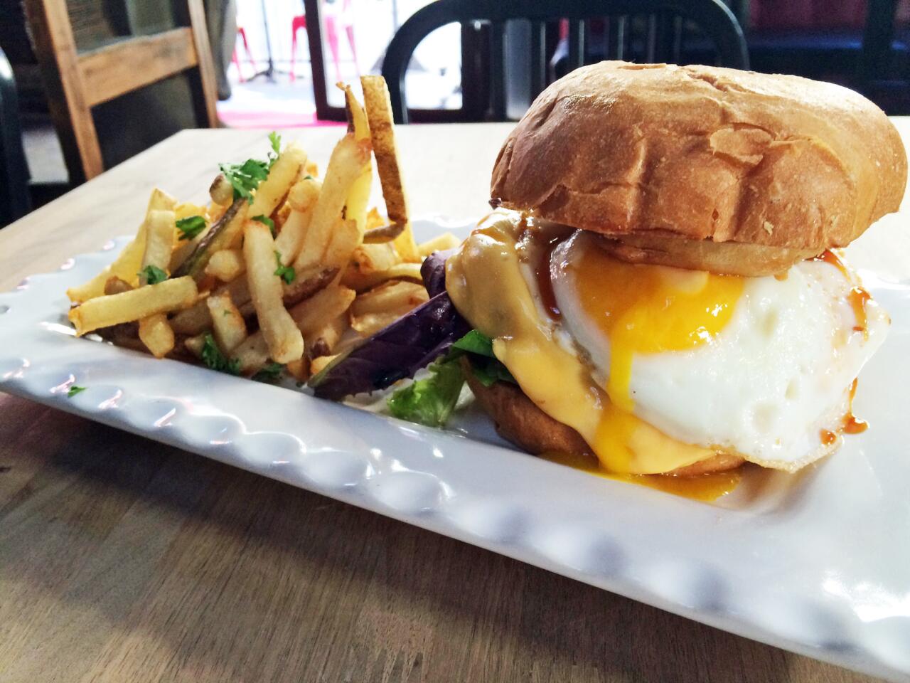 The Edwin Mills burger topped with cheddar cheese, a fried egg, onion rings and BBQ sauce.