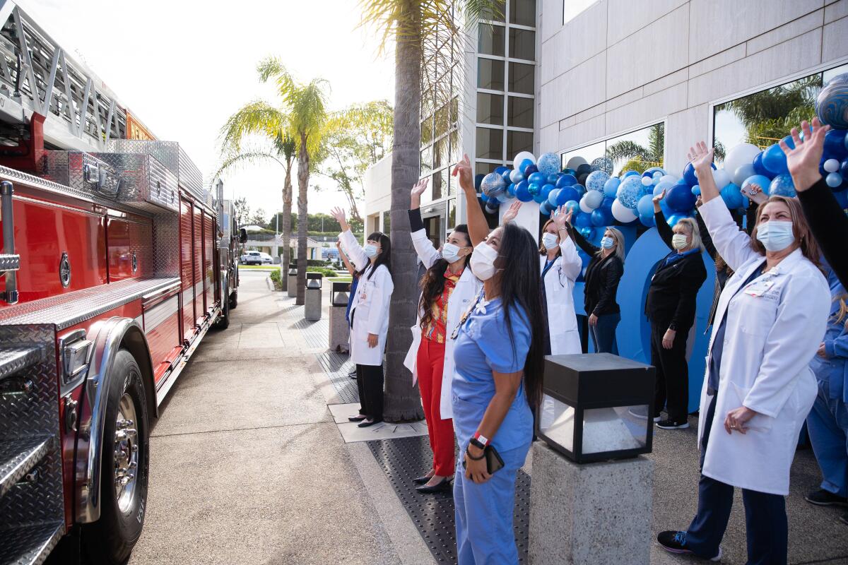 Doctors and staff from City of Hope Newport Beach wave to a fire truck from the Newport Beach Fire Department.