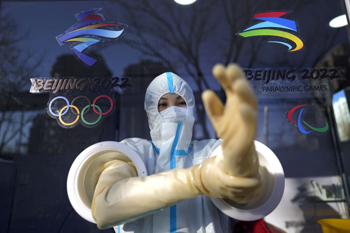 A worker prepares to administer a COVID-19 test at the 2022 Winter Olympics.