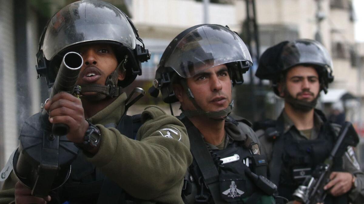 Israeli soldiers hold a position during clashes with Palestinian protesters in Halhul, north of the occupied West Bank city of Hebron, on Feb. 17.