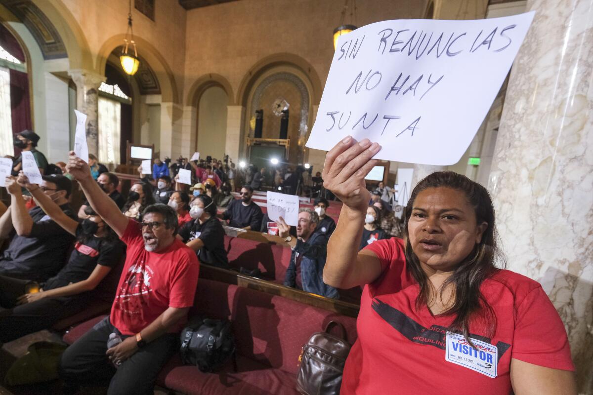 Ofelia Platon, right, from Oaxaca, holding a sign while protesting before the cancellation of the Los Angeles City Council meeting Wednesday, Oct. 12, 2022 in Los Angeles. (AP Photo/Ringo H.W. Chiu)
