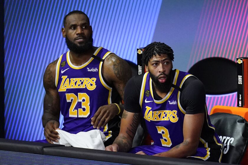 Los Angeles Lakers' LeBron James (23) and Anthony Davis (3) watch from the bench during the second half of an NBA conference semifinal playoff basketball game against the Houston Rockets Friday, Sept. 4, 2020, in Lake Buena Vista, Fla. The Rockets won 112-97. (AP Photo/Mark J. Terrill)