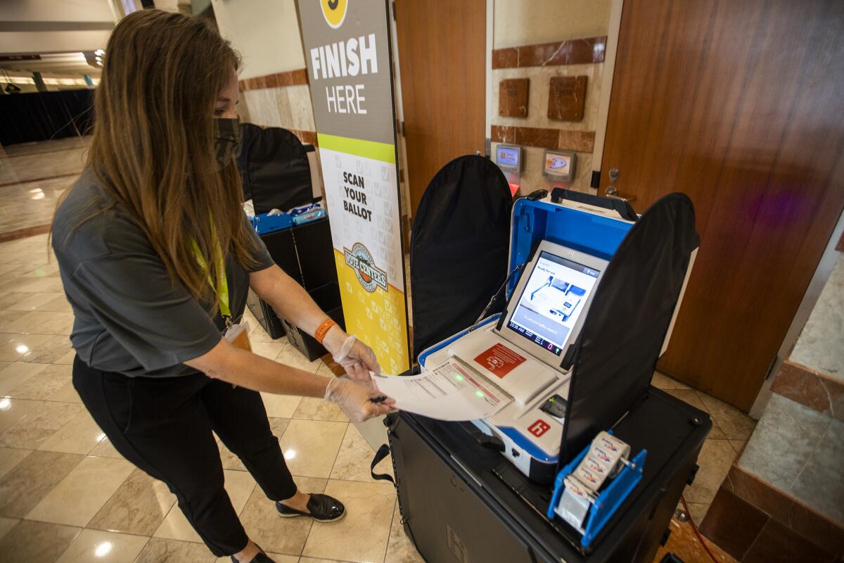 A woman casts a ballot at a machine.