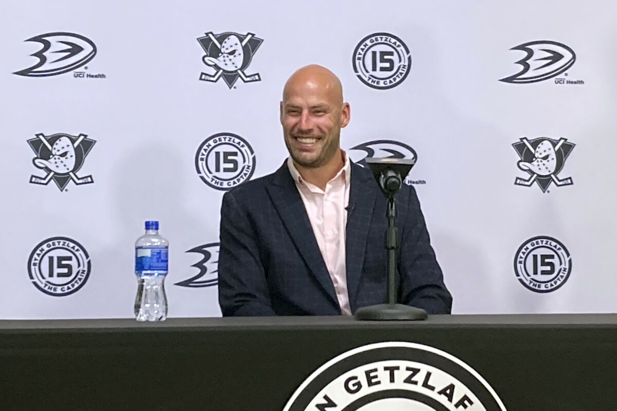 Anaheim Ducks captain Ryan Getzlaf smiles at his family during an NHL hockey news conference, Tuesday, April 5, 2022, at the Honda Center in Anaheim, Calif., announcing his retirement. Getzlaf will end a 17-year NHL career spent entirely with the Ducks at the conclusion of the season. (AP Photo/Greg Beacham)