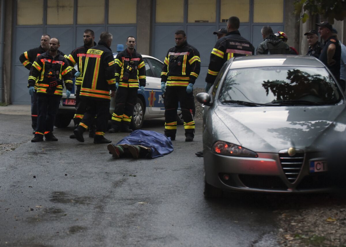 Los bomberos permanecen junto a un cadáver en el lugar donde un hombre mató a varias personas