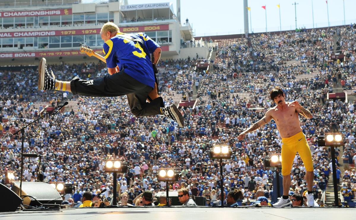 The Red Hot Chili Peppers' bassist Flea and singer Anthony Kiedis perform with the group Sunday before the Los Angeles Rams game. The Chili Peppers will tour in 2017.